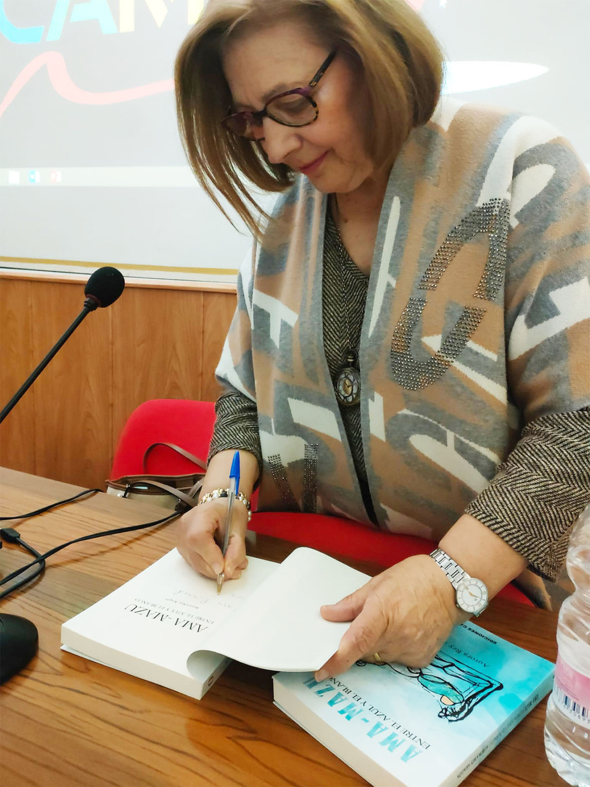 Aurora Rey Aragón firmando ejemplares de su novela Ama-Mazu
