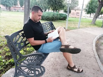 David García Rodríguez leyendo en un banco del parque Huerta Asaura de Argamasilla de Calatrava