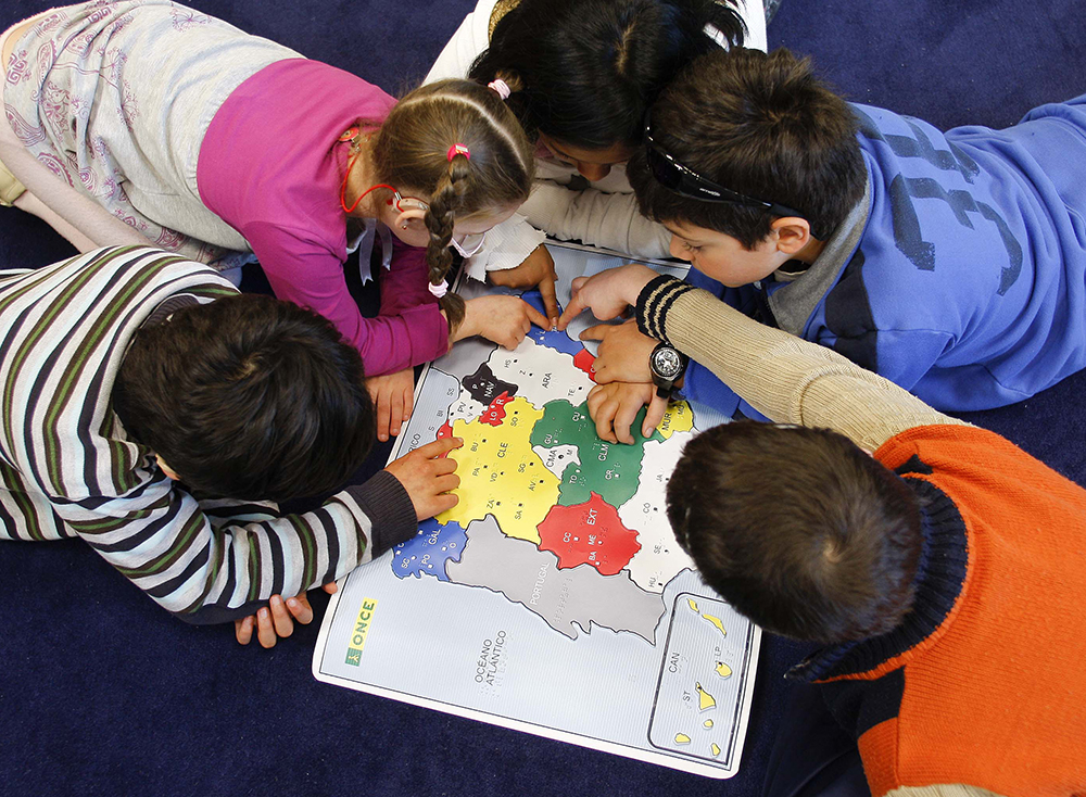 Alumnos del Colegio de la ONCE en Madrid, estudiando el mapa de España