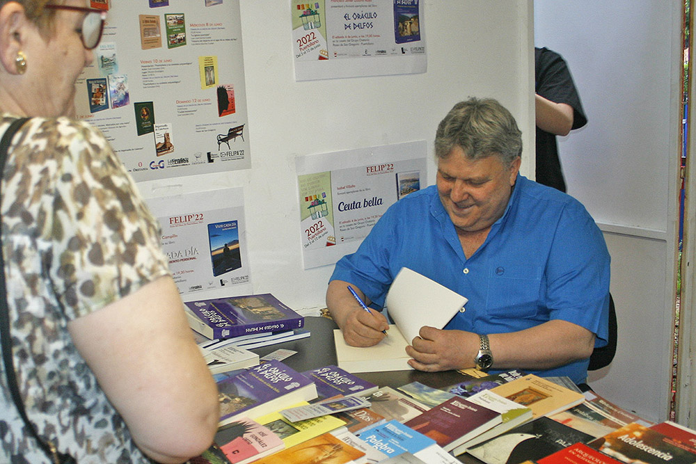 Francisco Javier Lozano Raya firmando ejemplares de su libro El Oráculo de Delfos en la Feria del Libro de Puertollano